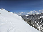 Steep snow slope ends in a several hundred foot cliff. To the left is a 1000+ foot cliff.